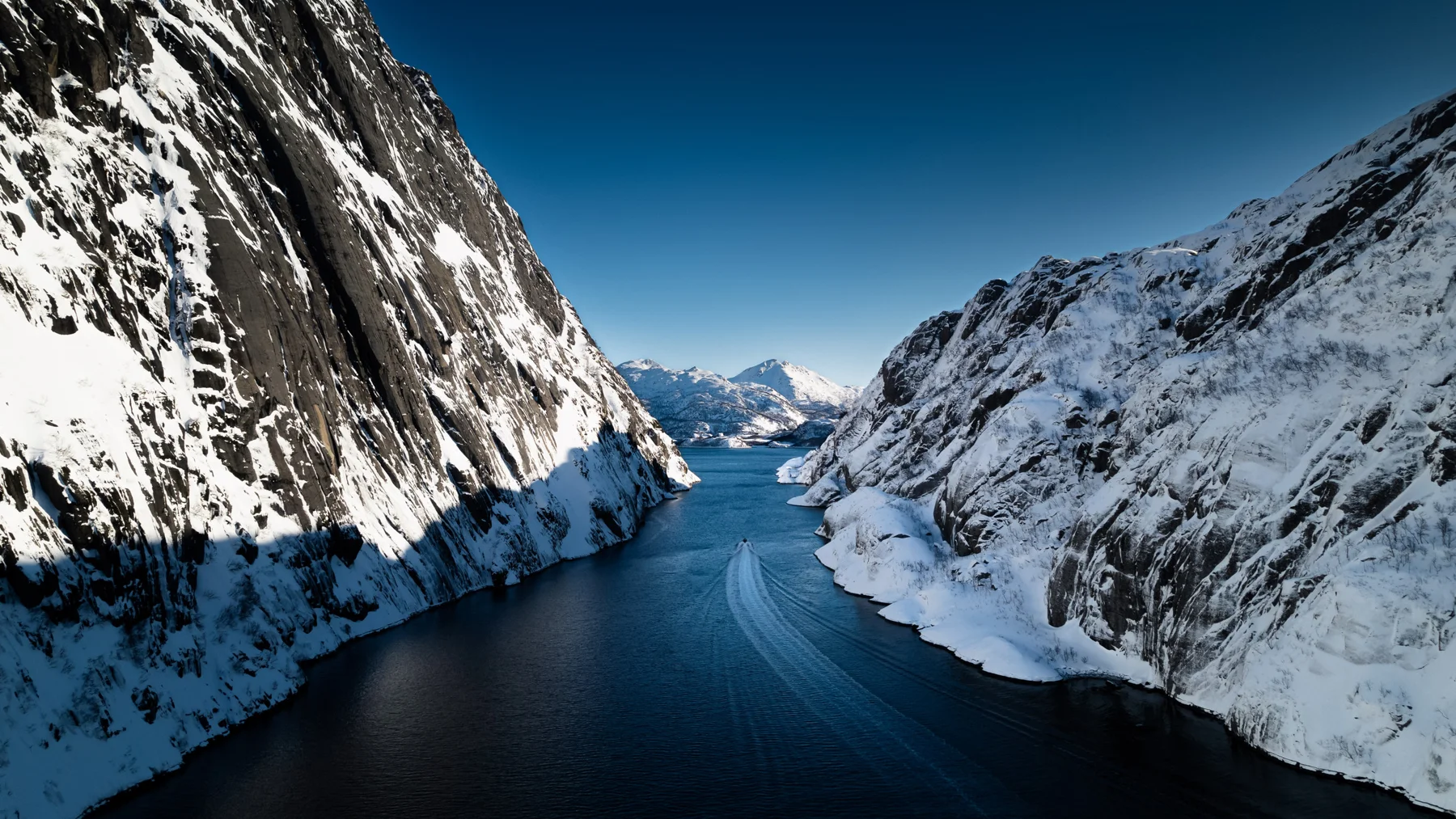 Trollfjorden mellom snødekte fjell i Lofoten. Foto: XXLofoten / Carl Filip Olsson.